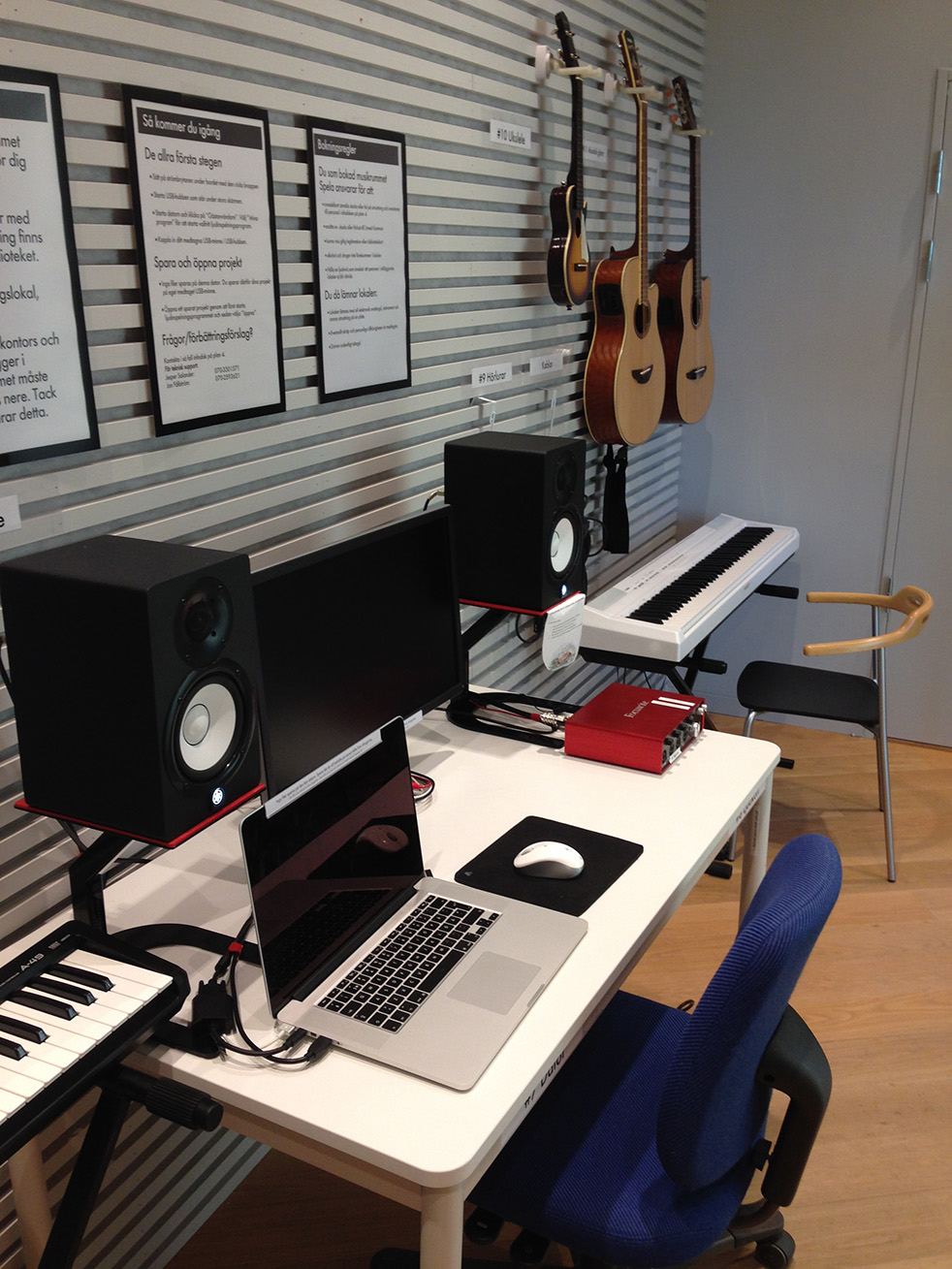 En dator på ett bord, omgiven av högtalare och olika instrument avsedda för ljudinspelning.